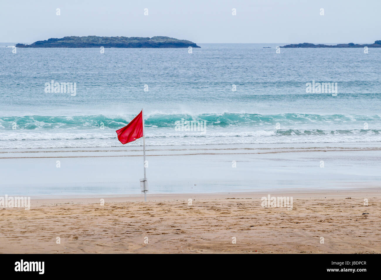 Rote Fahne am Strand von Portrush, Nordirland unter Angabe einer Gefahr wie hohe Brandung oder starke Strömungen Stockfoto