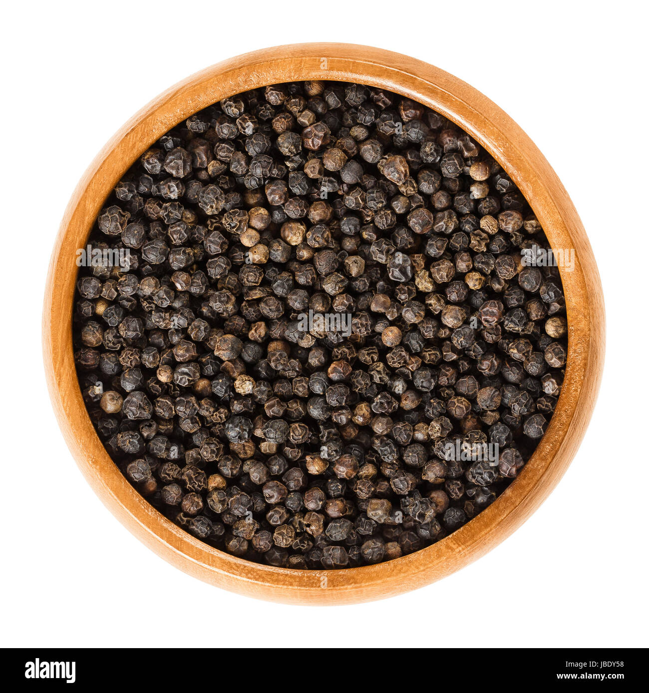 Schwarzer Pfeffer in Holzschale. Getrocknete Beeren des Piper Nigrum nennt man Pfefferkörner. Aus der Unreife Steinfrüchte von der Pfefferpflanze hergestellt. Gewürz. Stockfoto