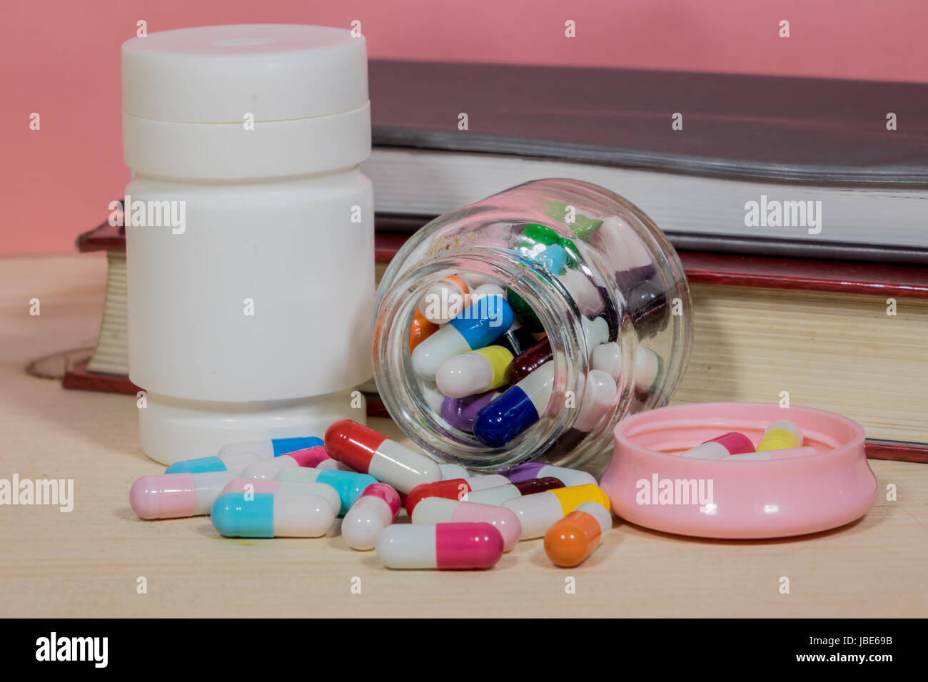 Bücher-Pillen. Medizin und Gesundheit Bücher auf einem Holztisch. Stockfoto