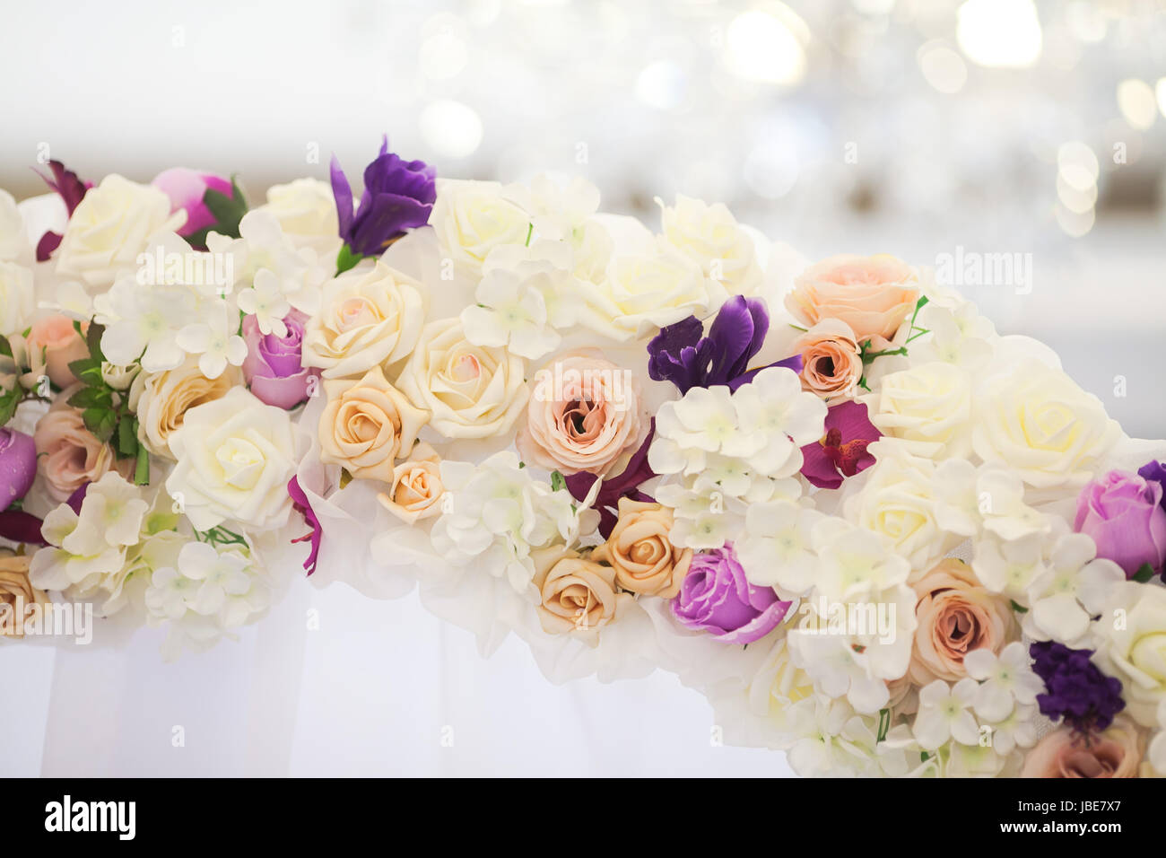 Blumenbogen aus frischen Farben für eine Trauung im Restaurant auf einem weißen Hintergrund mit einem leichten Hochzeit-Dekor. Stockfoto