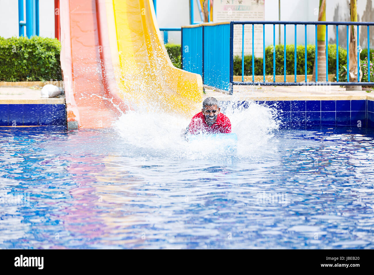 Happy 1 Indischen älterer Mann schieben Spritzer Waterpark Schwimmbad Spaß Stockfoto