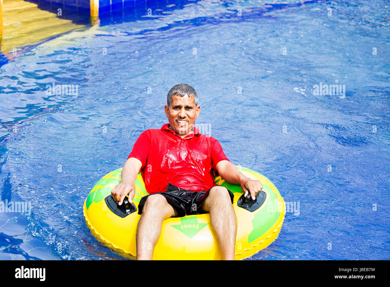 Happy 1 Indischen älterer Mann Entspannende aufblasbaren ring Resort Pool genießen Lächelnd Stockfoto