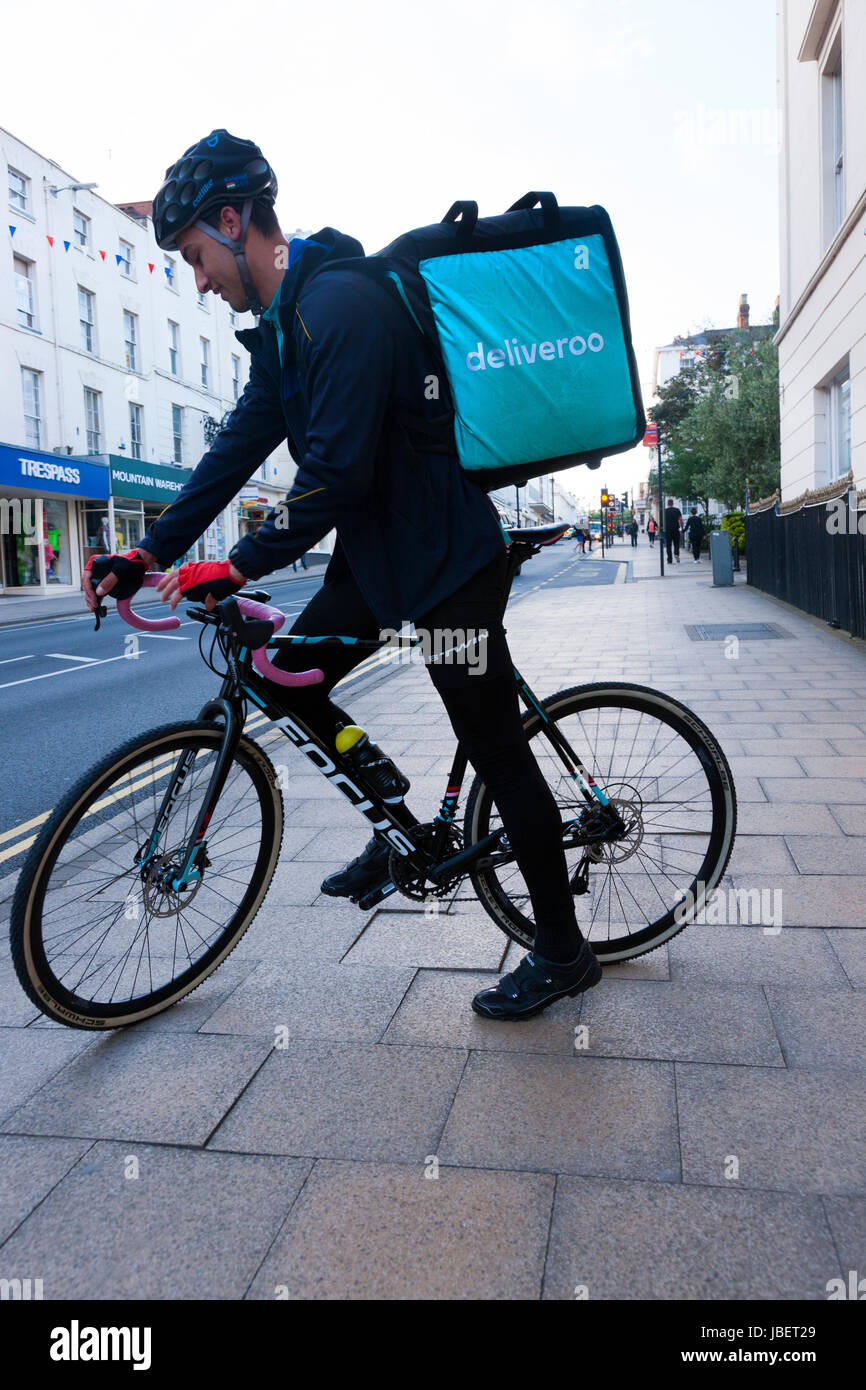 Deliveroo Speisen zum Mitnehmen Kurier Pedal Lieferzyklus / Push Fahrrad Radfahrer machen eine Lieferung laufen in Royal Leamington Spa. GROßBRITANNIEN (88) Stockfoto