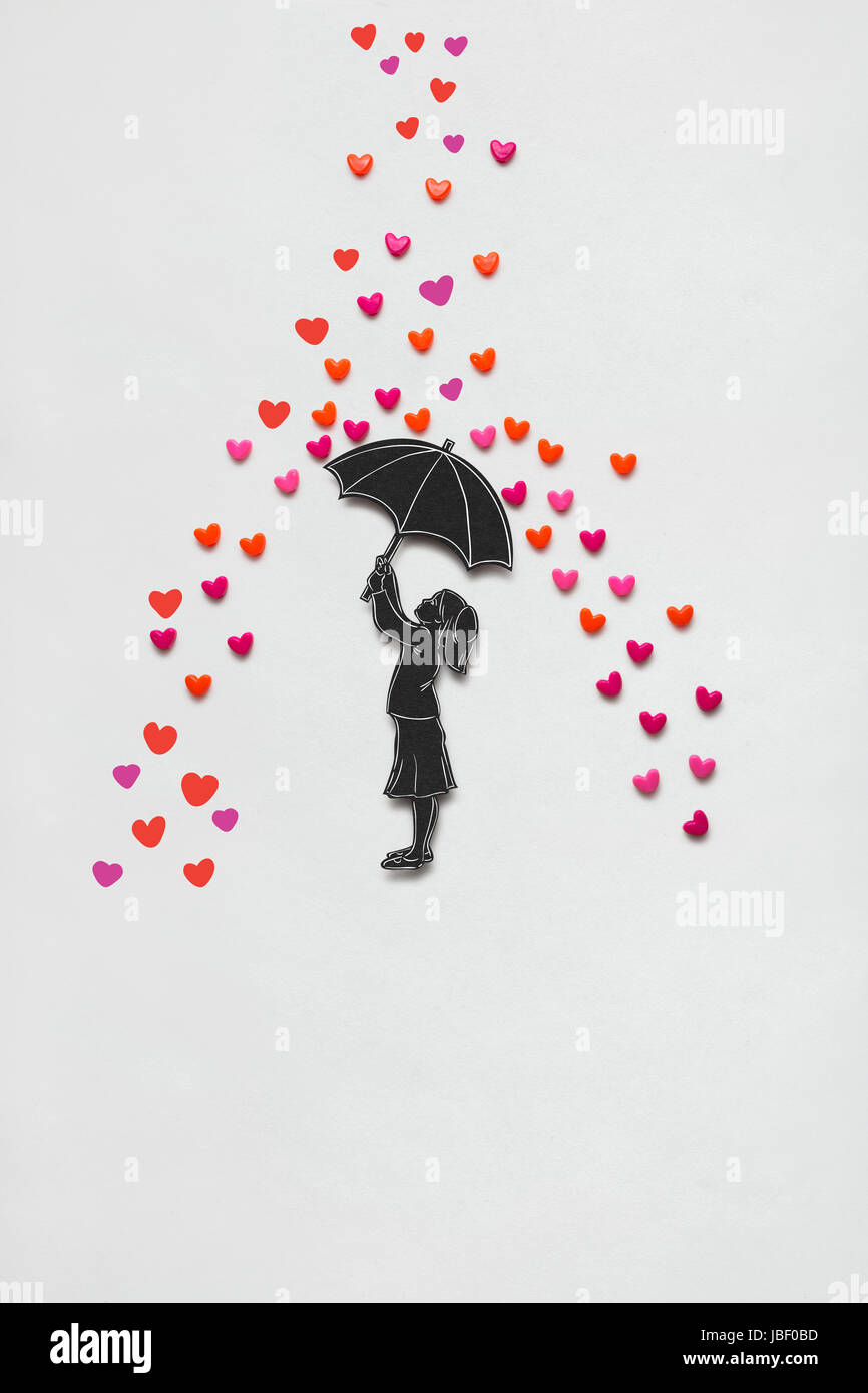 Kreative Valentines Konzept Foto von einem Mädchen mit Regenschirm und Regen Herzen auf weißem Hintergrund. Stockfoto