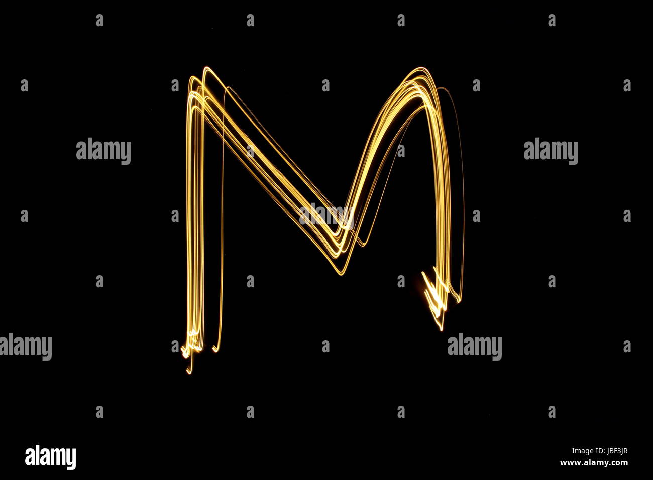 Gold Buchstabe M, Licht-Malerei-Fotografie, Alphabet-Serie, vor schwarzem Hintergrund Stockfoto