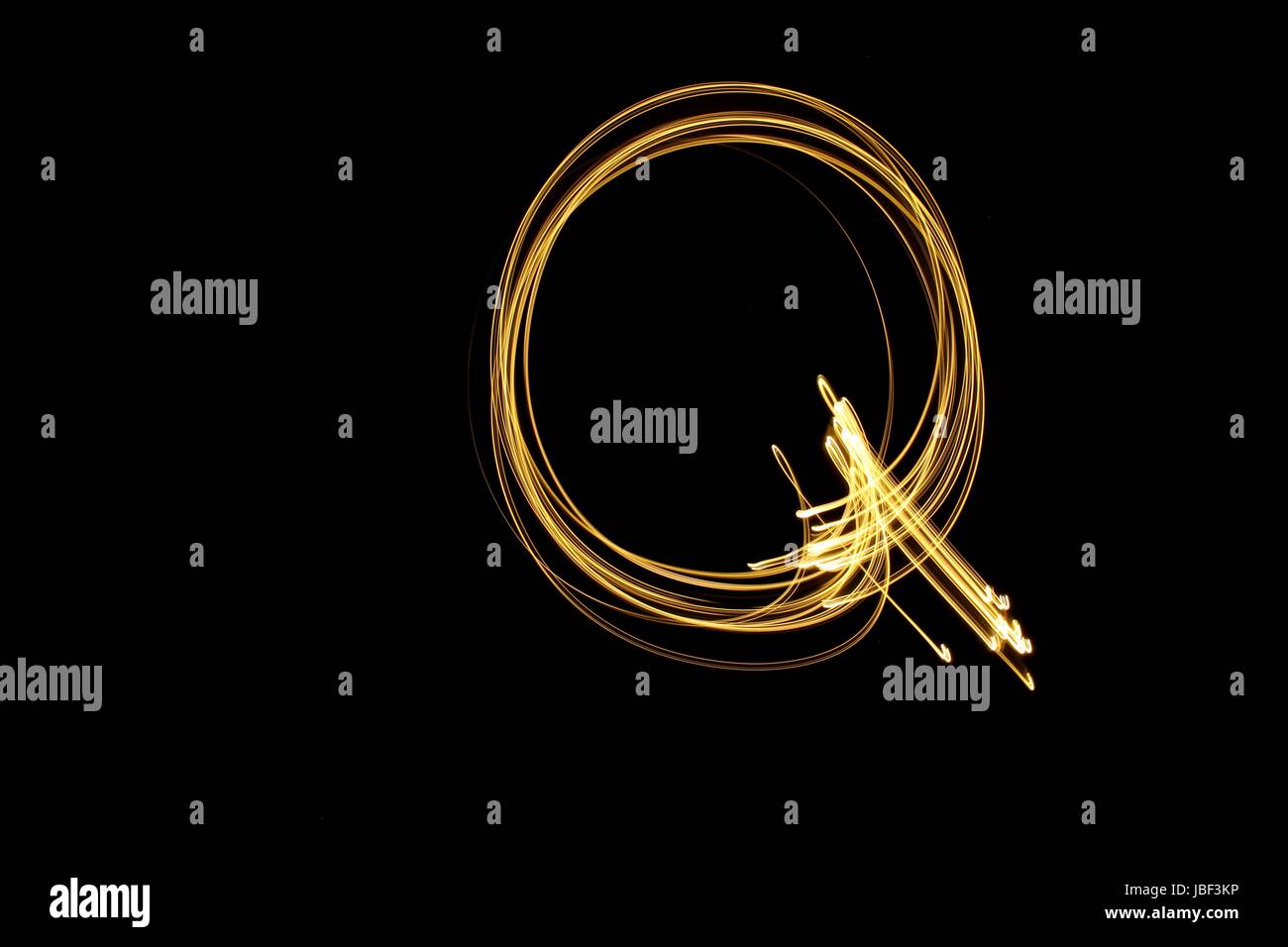 Gold Buchstabe Q, Licht-Malerei-Fotografie, Alphabet-Serie, vor schwarzem Hintergrund Stockfoto