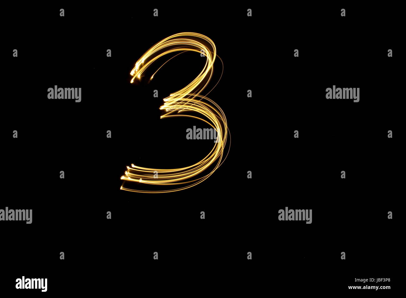 Gold Nummer 3, Licht Malerei Fotografie, Nummernserie, vor schwarzem Hintergrund Stockfoto