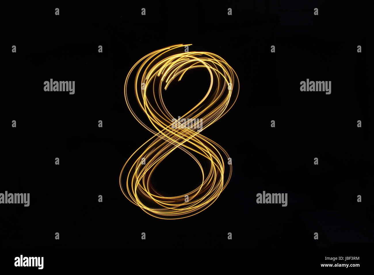Gold Nummer 8, Licht Malerei Fotografie, Nummernserie, vor schwarzem Hintergrund Stockfoto