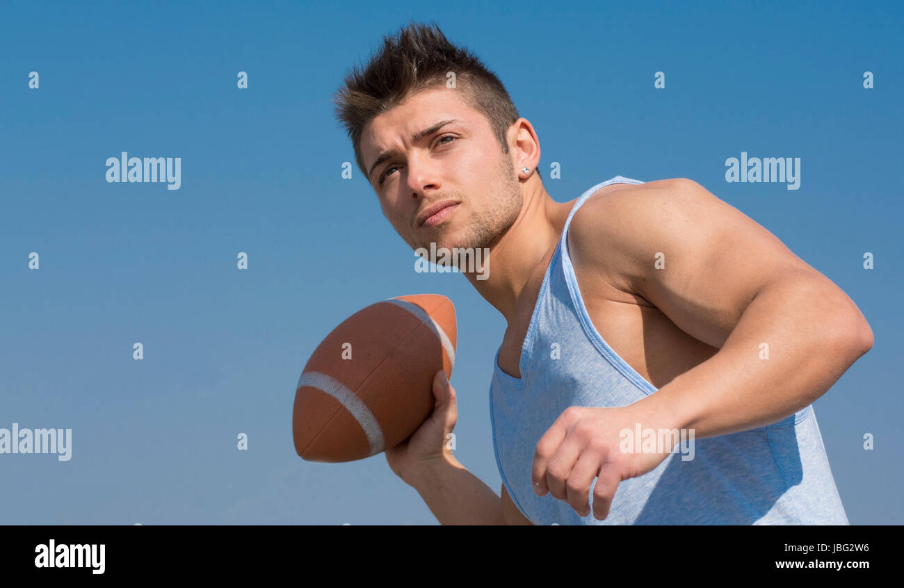 Muskuläre american Footballspieler bereit, den Ball in der hand zu werfen. Im Freien Schuss Stockfoto