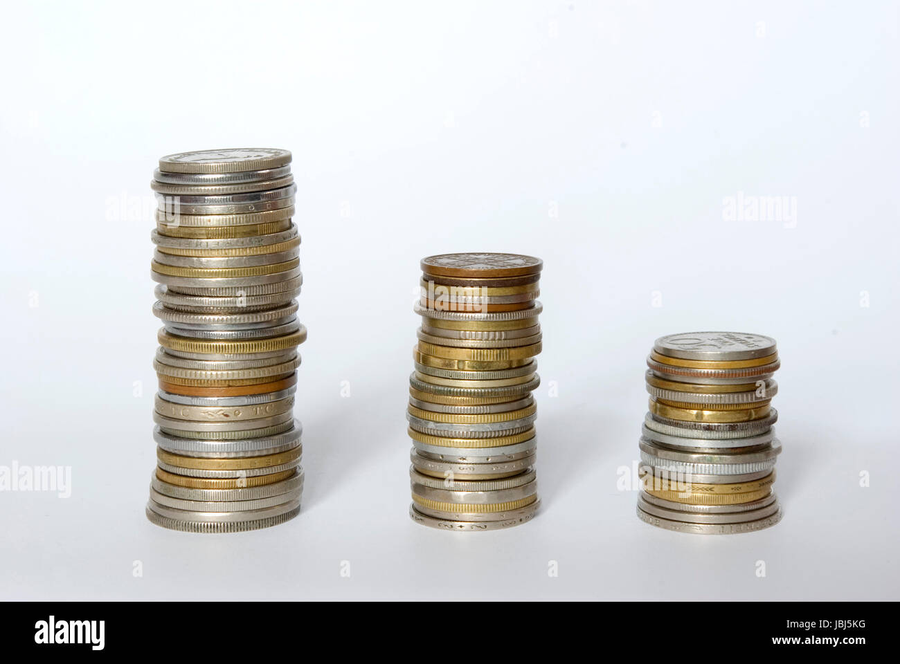 drei Türme der Münzen isoliert auf eine weiße Stockfoto
