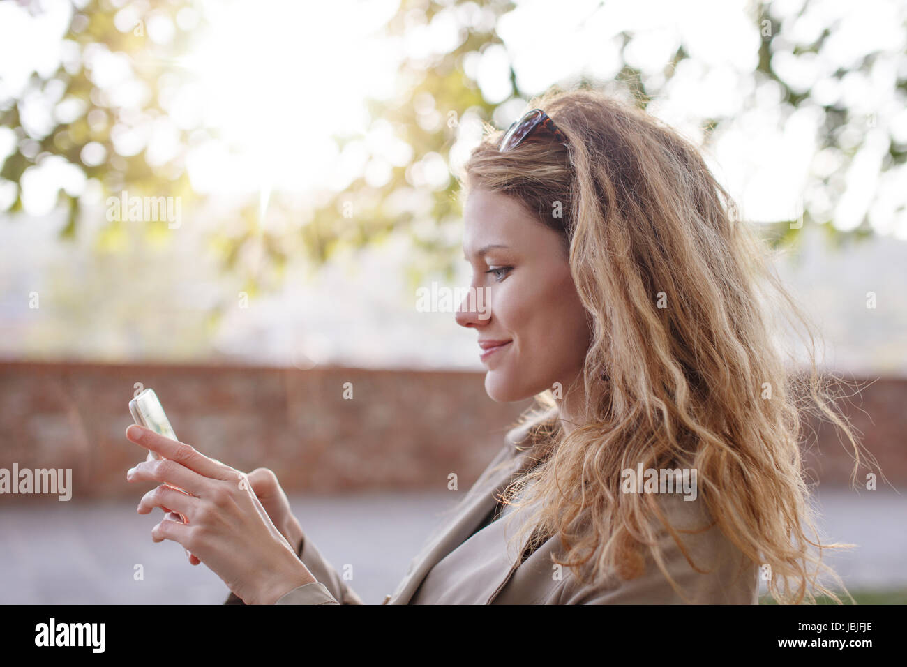 Frau messaging oder auf Outdoor-Smartphone spielen Stockfoto