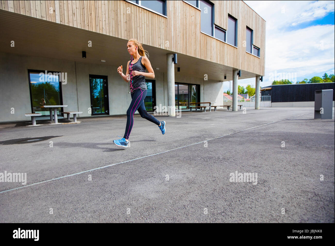 Sportliche junge Frau läuft durch den Bau Stockfoto