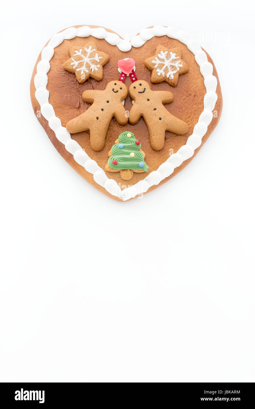 Lebkuchenherz mit Lebkuchenmänner, Lebkuchen Sterne und ein Weihnachtsbaum Cookie auf weißem Hintergrund mit vielen textfreiraum verziert. Stockfoto