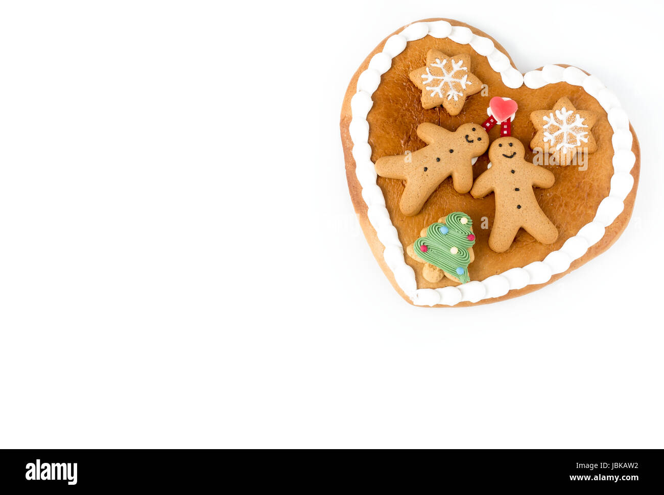 Nahaufnahme von einer süßen Lebkuchenherz verziert mit Lebkuchenmänner, Lebkuchen Sterne und ein Weihnachtsbaum Cookie auf weißem Hintergrund mit vielen co Stockfoto