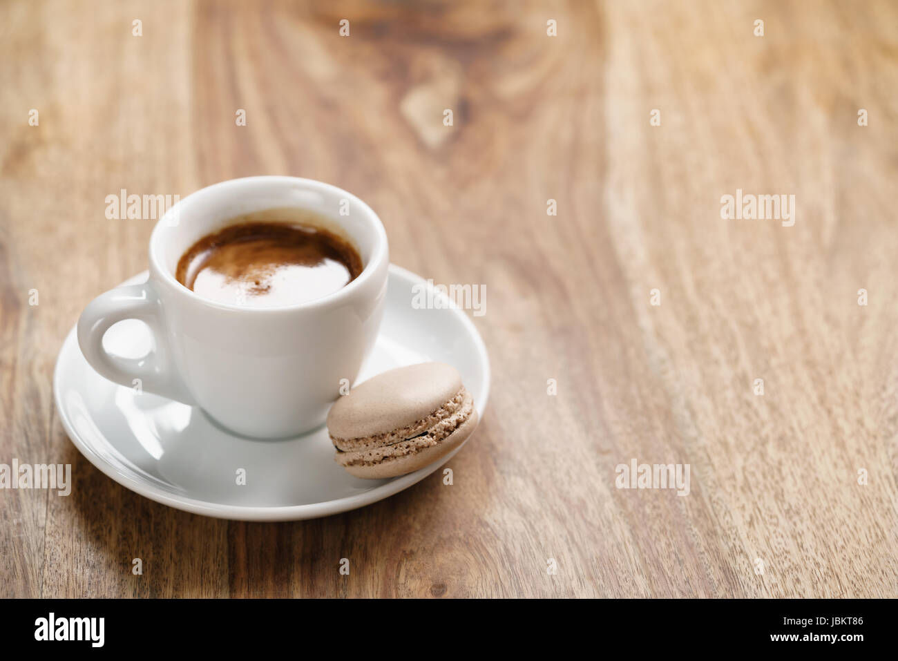 Tasse frischen Espresso mit Macaron auf Holztisch Stockfoto