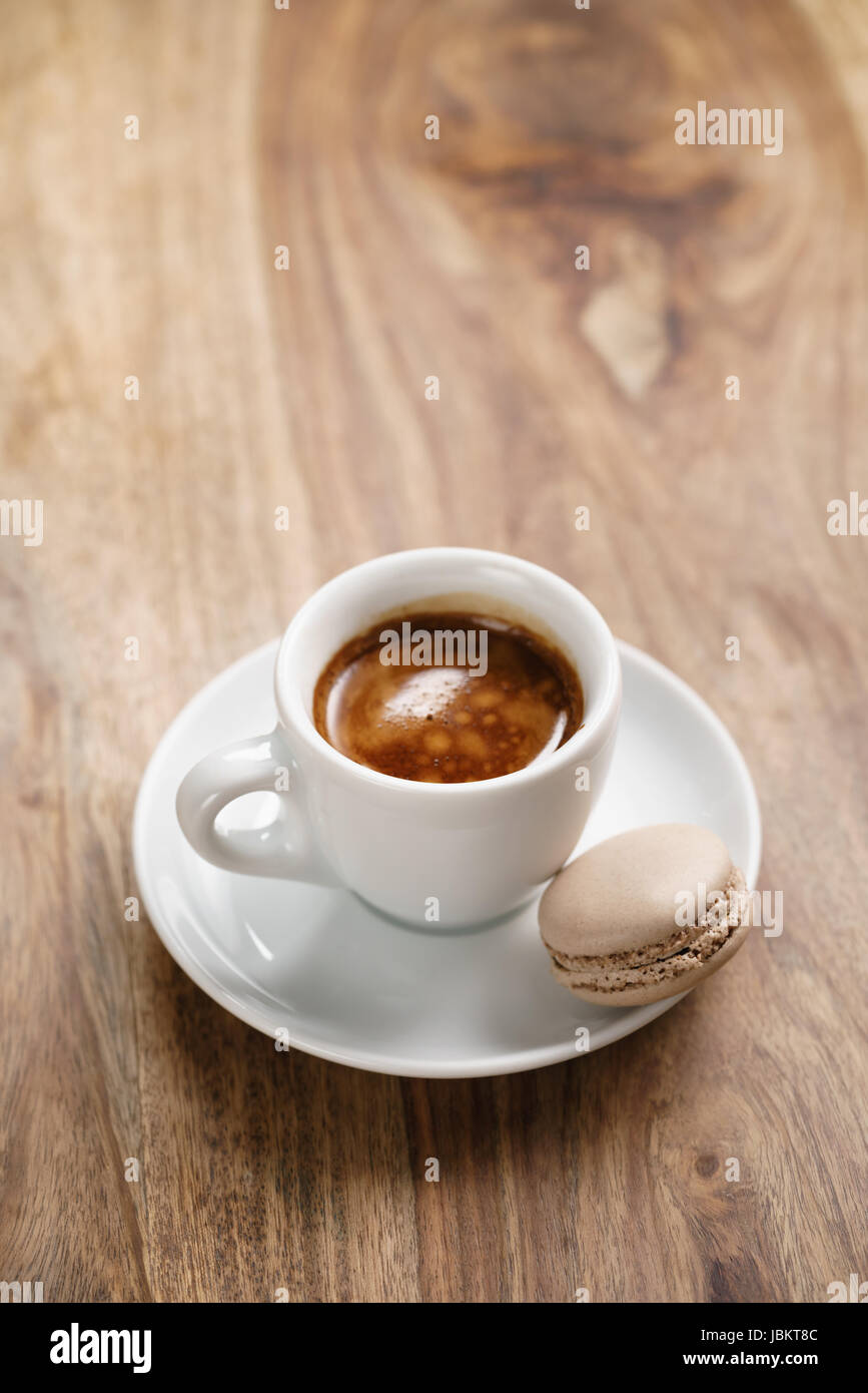Tasse frischen Espresso mit Macaron auf Holztisch Stockfoto