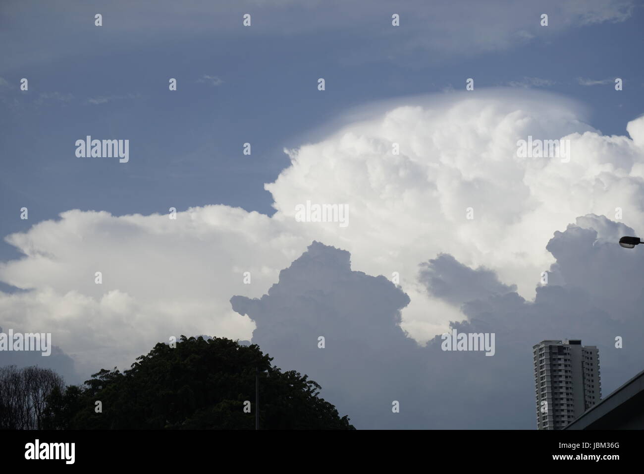 blauer Himmel mit geschichteten weißen und grauen Wolken Stockfoto