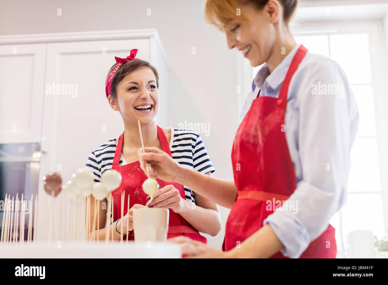 Lächelnde Frau Cateringservice backen, machen Cupcake erscheint in Küche Stockfoto