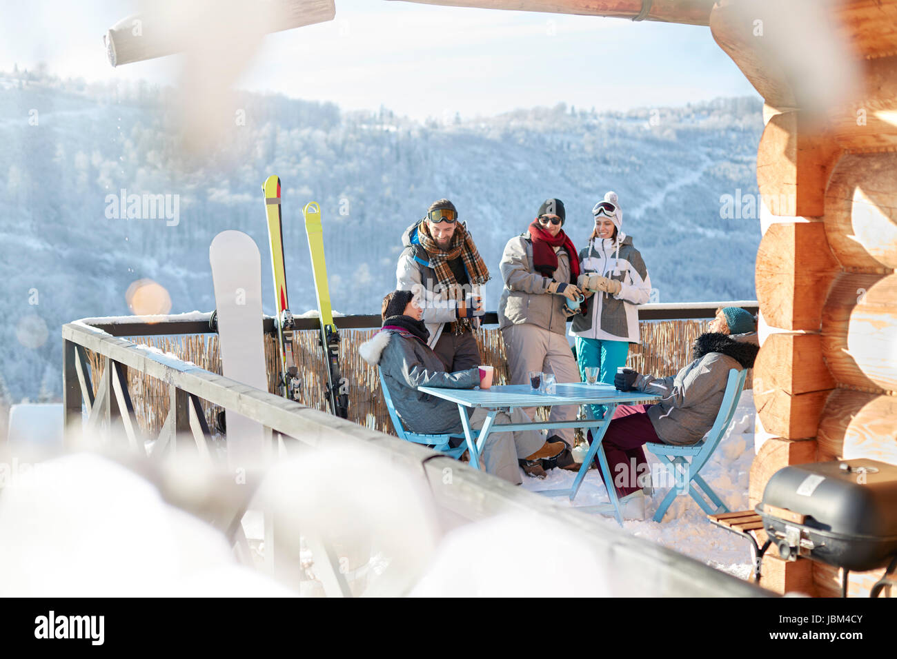 Skifahrer und Snowboarder Paare hängen auf sonnigen Kabine Balkon Apres-Ski Stockfoto