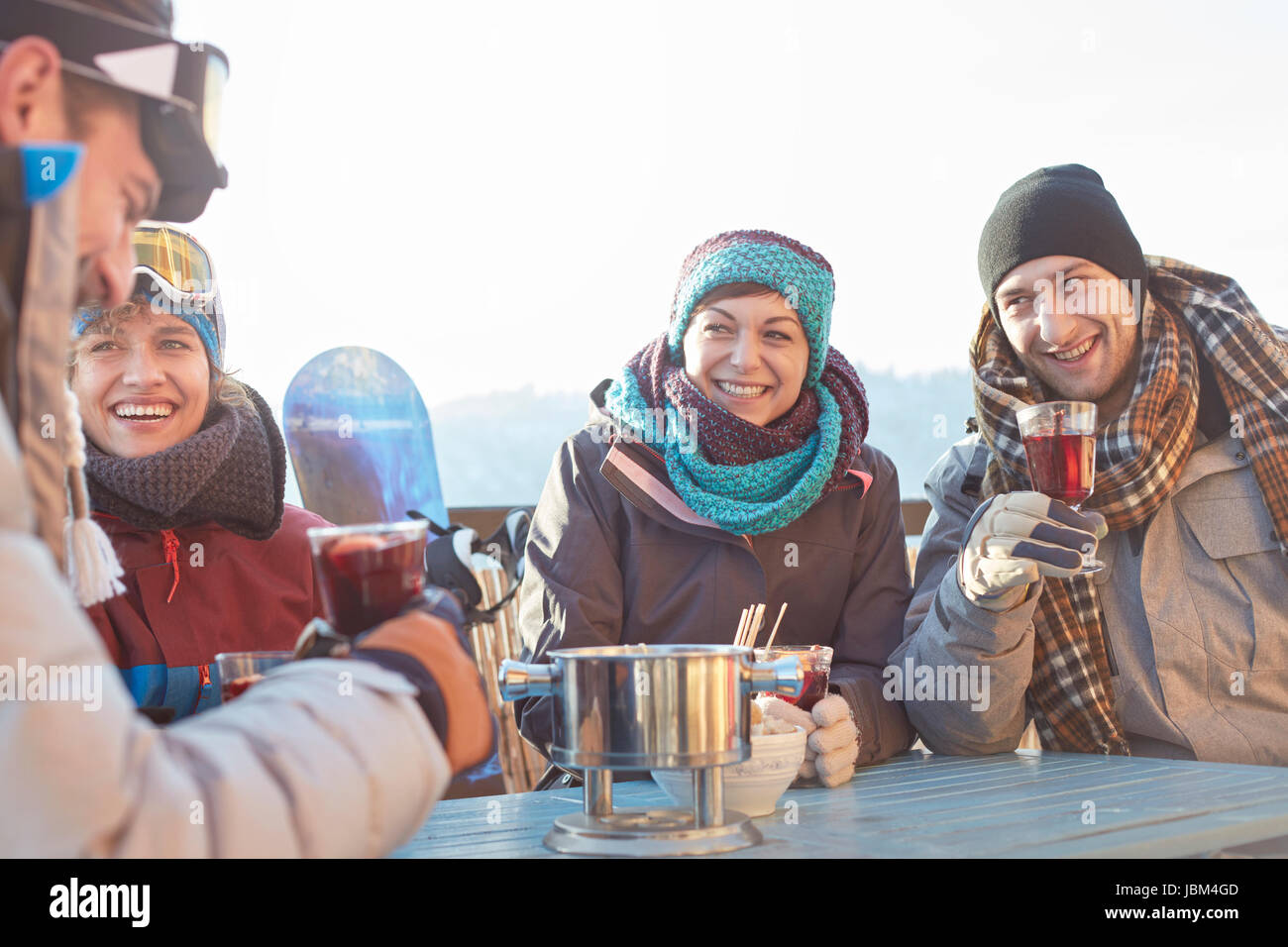 Snowboarder Freunde tranken Cocktails auf der sonnigen Terrasse Apres-Ski Stockfoto