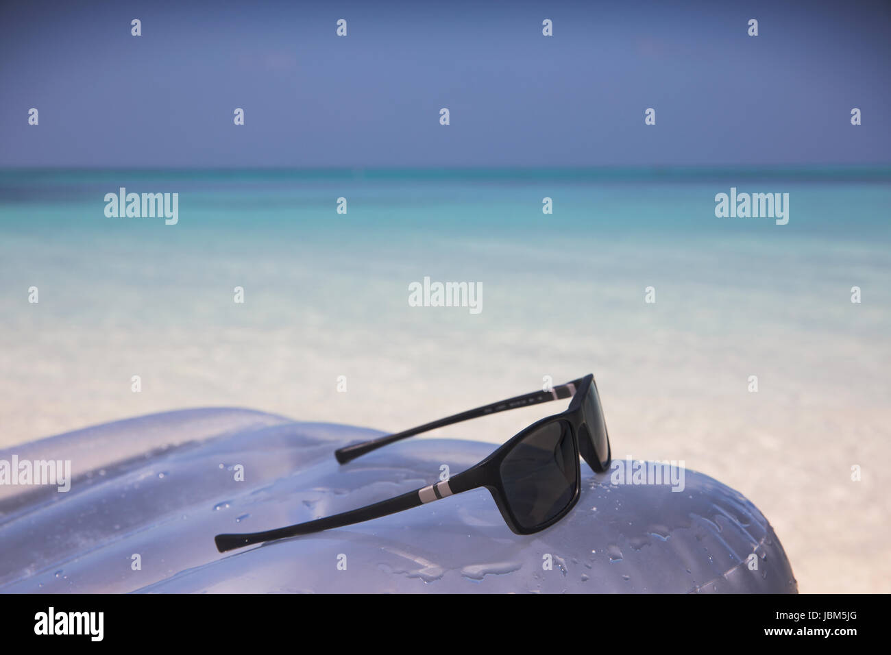 Sonnenbrille auf Schlauchboot im tropischen Ozean Blau Stockfoto