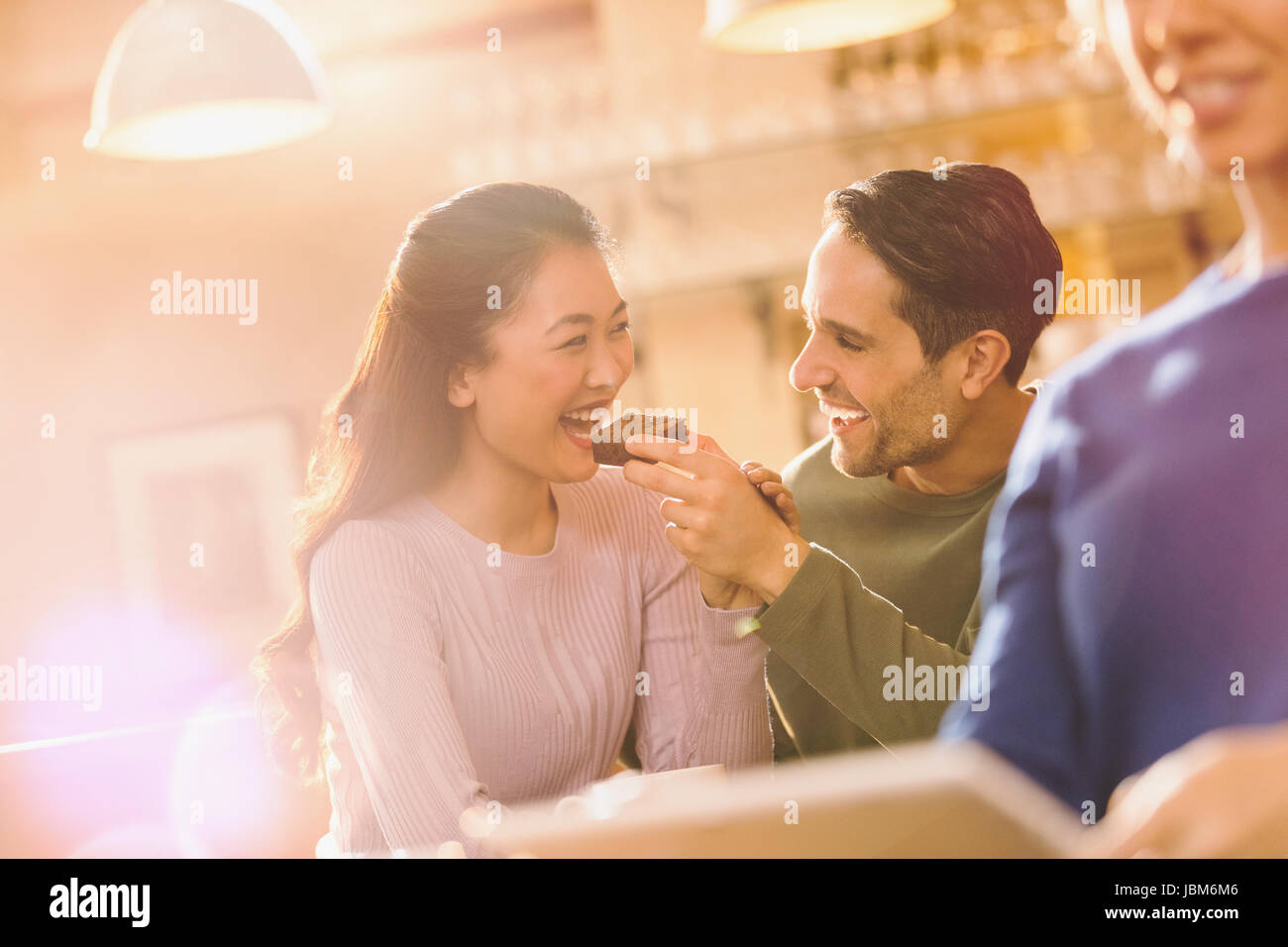 Spielerische Freund Fütterung Brownie Freundin im café Stockfoto