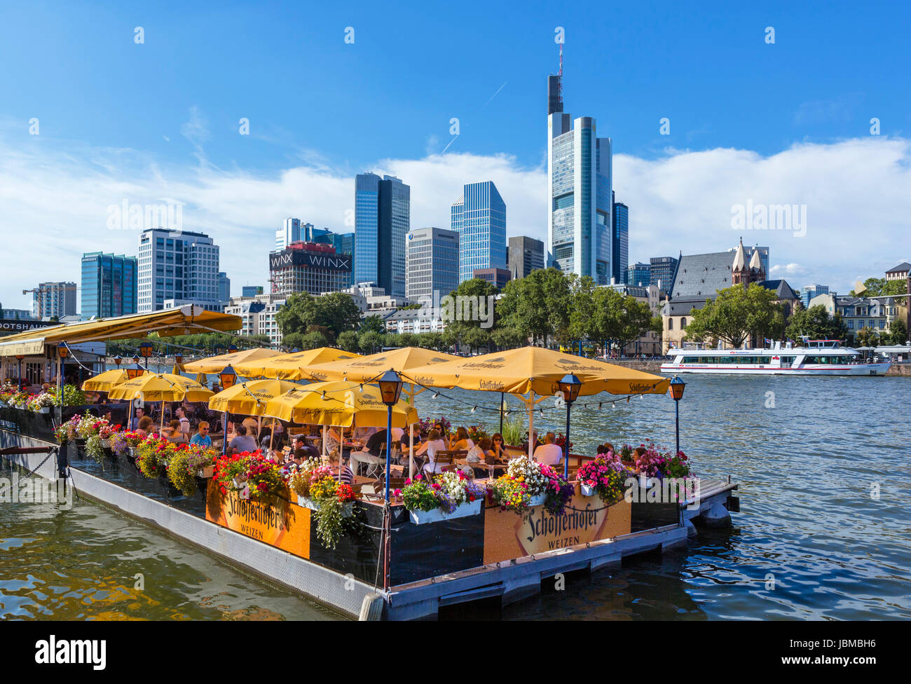 Schwimmendes Restaurant Bootshaus am Ufer des Mains mit der Skyline des Finanzzentrums hinter Frankfurt am Main, Hessen, Deutschland Stockfoto