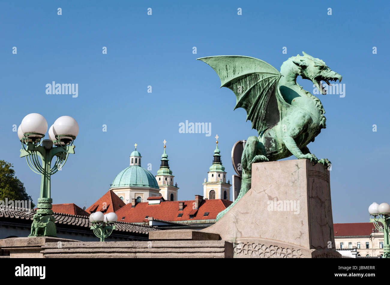 Dragon Bridge mit St. Nikolaus-Kathedrale im Hintergrund, in Ljubljana, Slowenien. Stockfoto