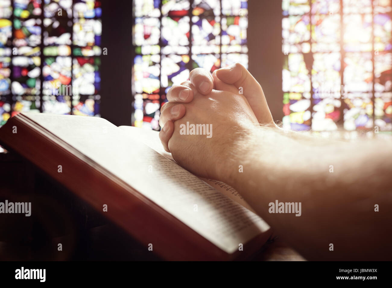Hände gefaltet im Gebet auf eine Bibel in kirchlichen Konzept für glauben, Spiritualität und religion Stockfoto