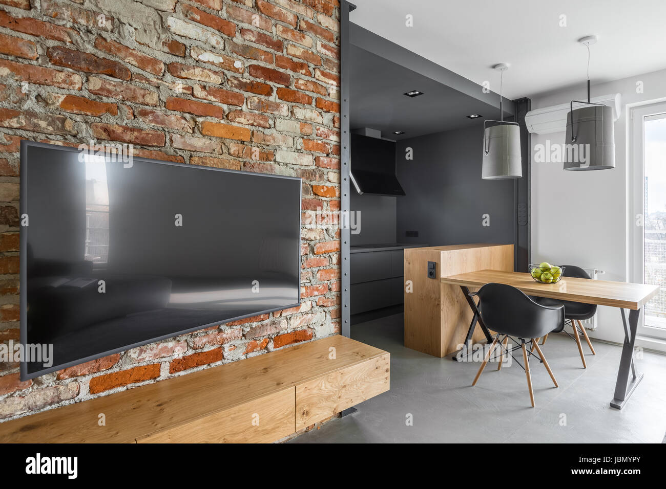 Modernes Apartment mit Mauer, Fernseher und Tisch aus Holz Stockfoto