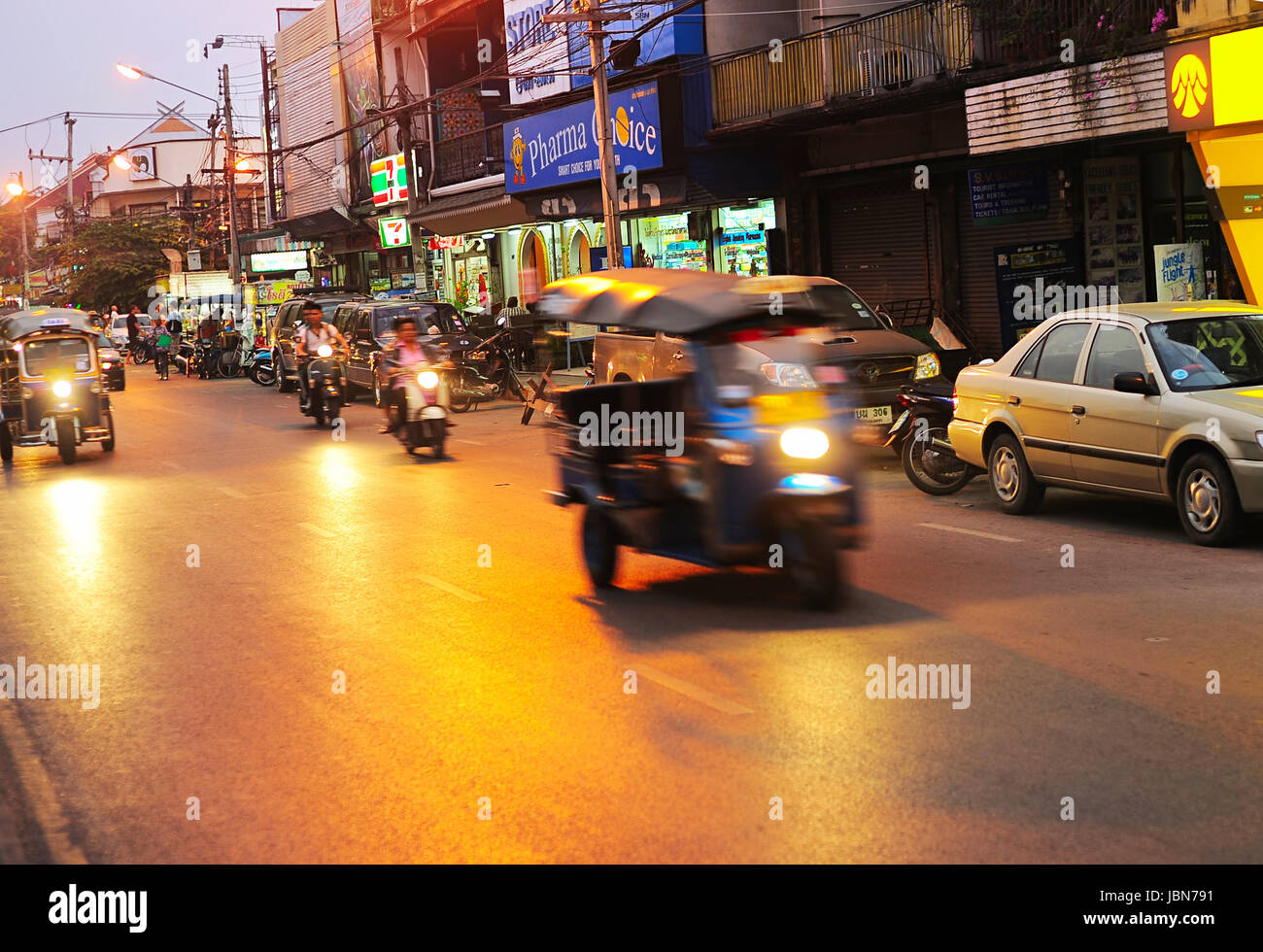 CHIANG MAI, THAILAND - 26. Februar 2013: Regen Verkehr auf einer Straße in der Abenddämmerung in Chiang Mai. Chiang Mai ist die größte und kulturell bedeutende Stadt im Norden Thailands Stockfoto