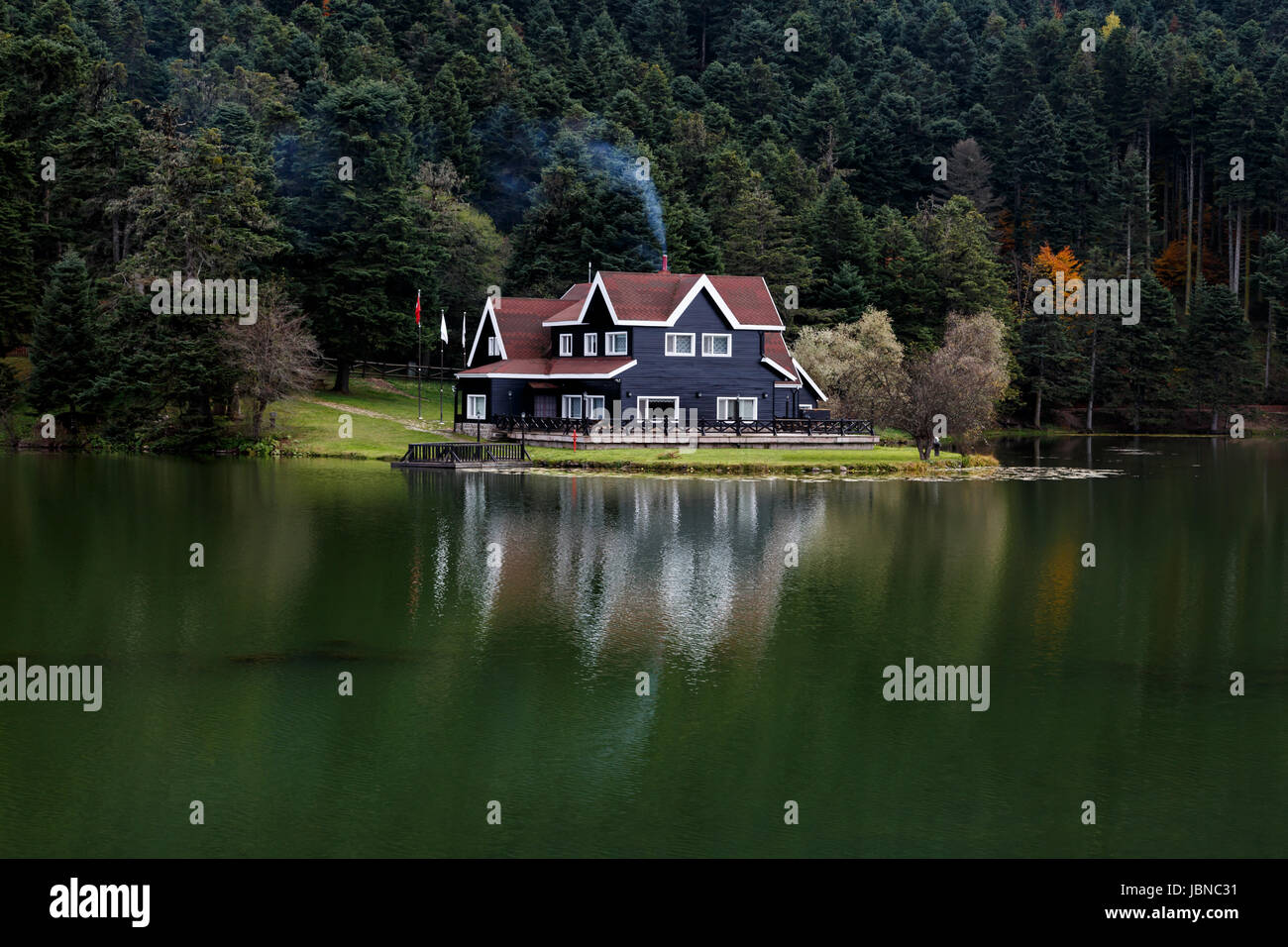 Holz-das Haus am See im Wald in Bolu Golcuk National Park, Türkei mit Reflexion am See am bewölkten Himmel. Stockfoto