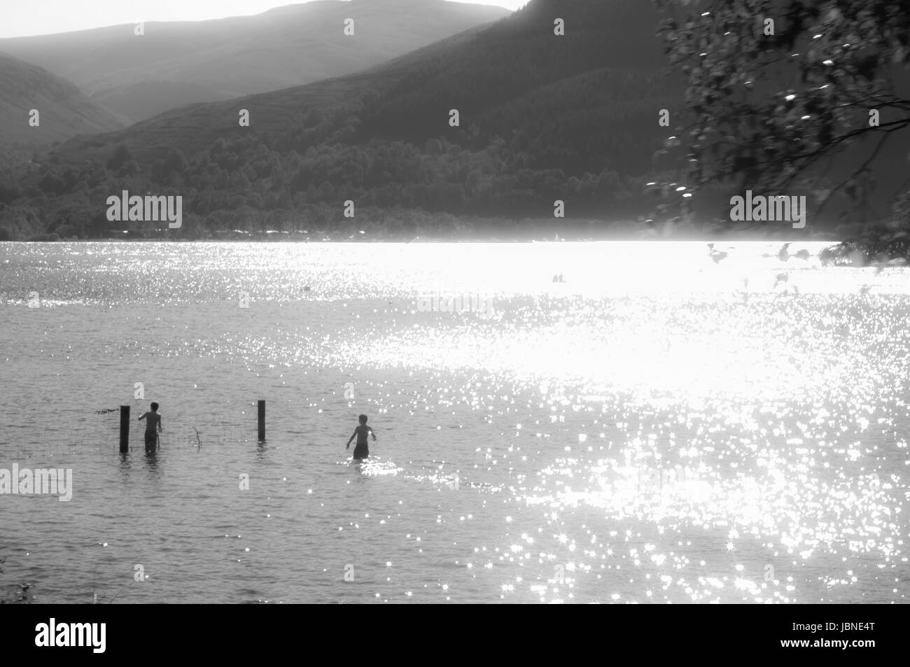 Jungen spielen in Loch Lomond, Schottland.  Der See ist eine malerische britischen Sommer malerische Aussicht. Stockfoto