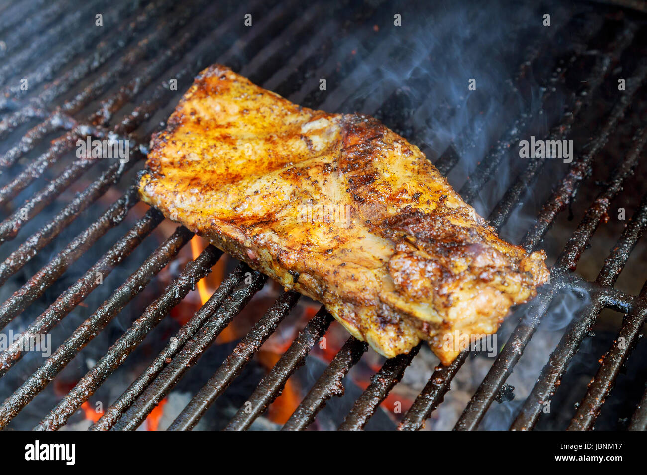 BBQ Schweinerippchen Kochen auf flaming Grill mit selektiven Fokus erschossen Stockfoto