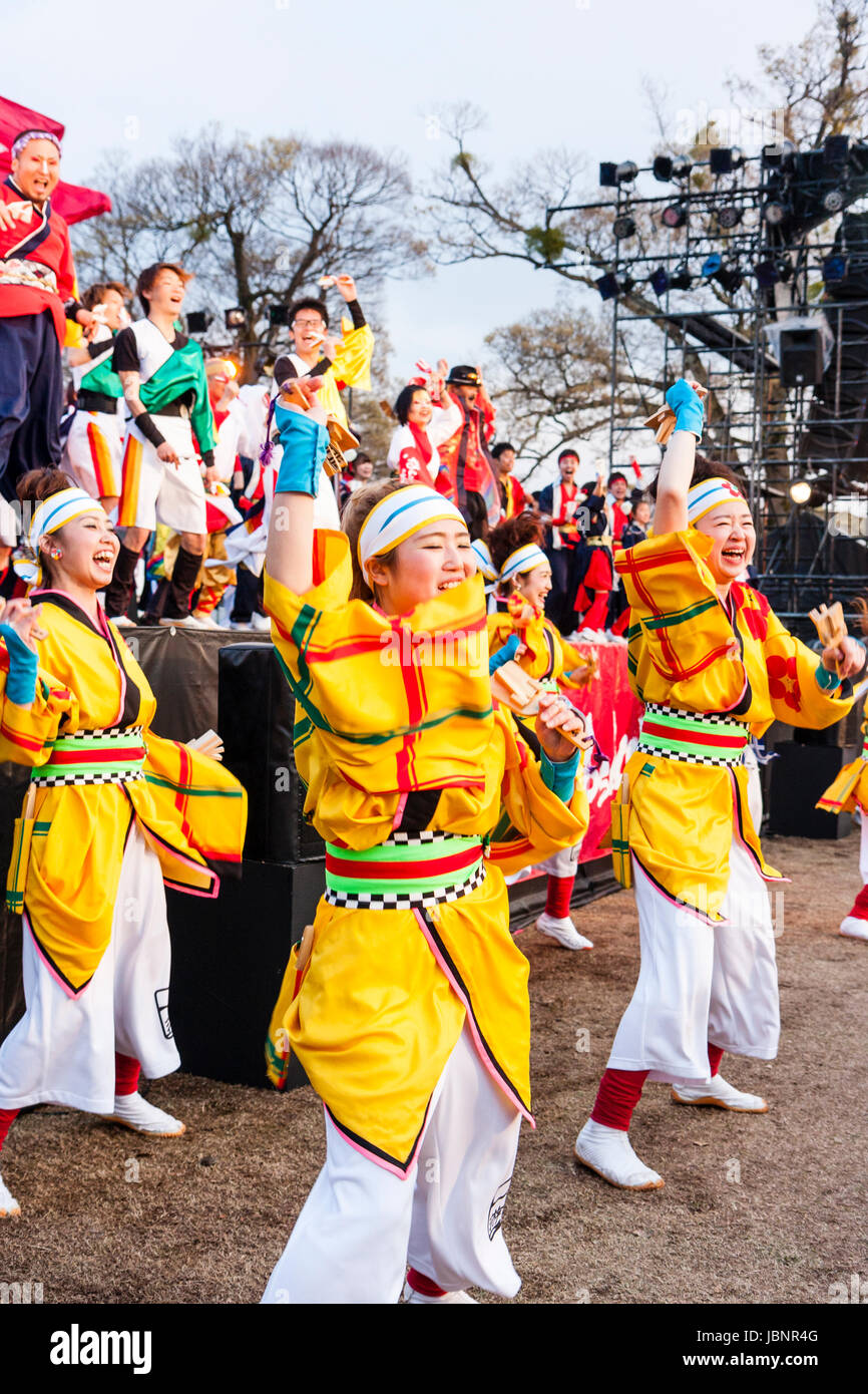 Hinokuni Yosakoi Dance Festival in Kumamoto, Japan. Junge Tänzerinnen in Gelb traditionelle Yukata Jacken, tanzen vor der Bühne. Stockfoto