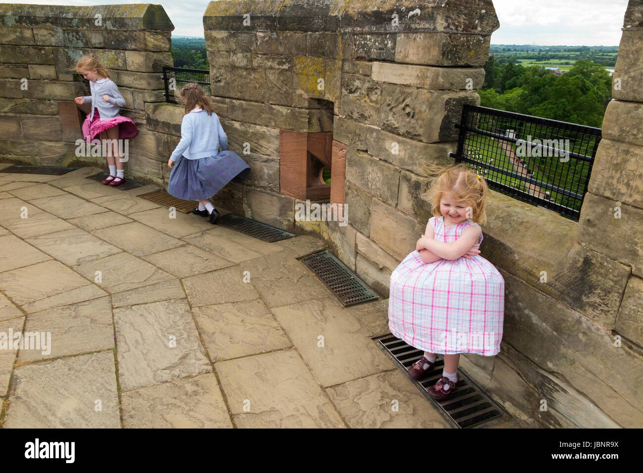 3 Schwestern Mädchen / Kinder / kids / Kinder spielen in der Up-Entwurf des Luft / wind weht an der Spitze des Kerls Tower, Warwick Castle in Warwickshire, UK. (88) Stockfoto