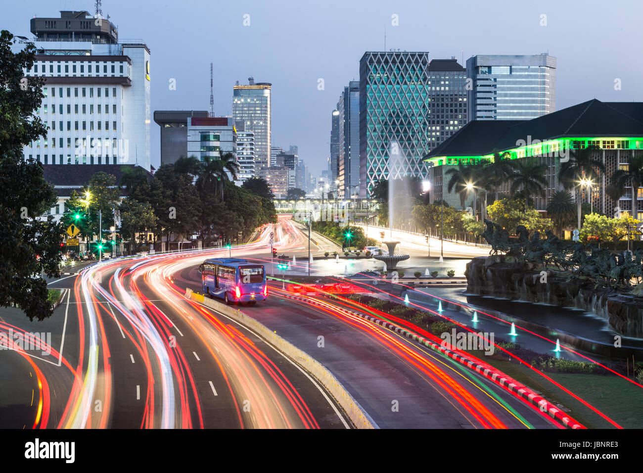 Verkehr, mit Bewegungsunschärfe, Eile entlang der Thamrin-Allee im Herzen der Innenstadt von Jakarta in Indonesien Hauptstadt in der Nacht gefangen. Stockfoto