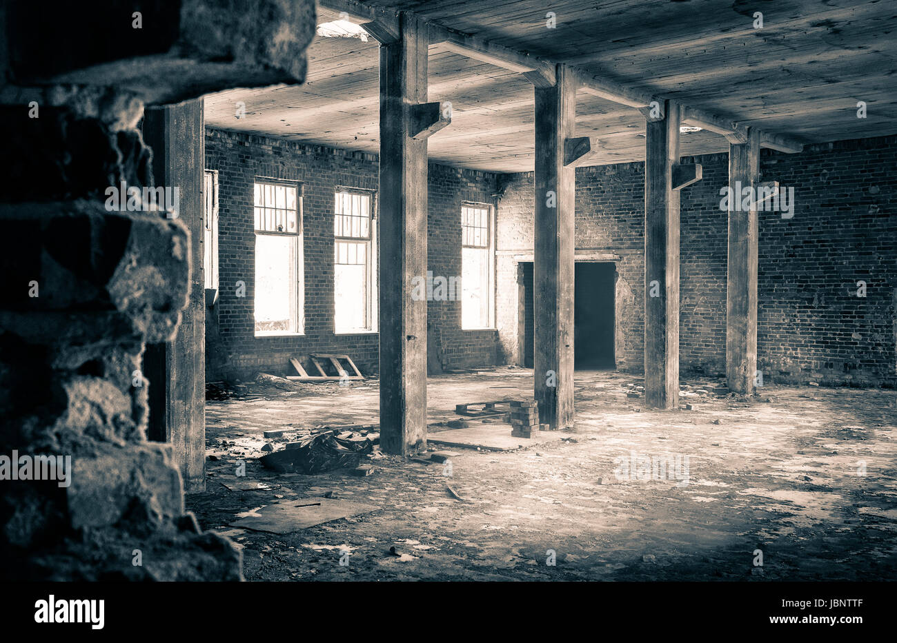 Die Aussicht aus einer alten, verlassenen Fabrik auf der Innenseite mit schönen Fensterlicht Stockfoto