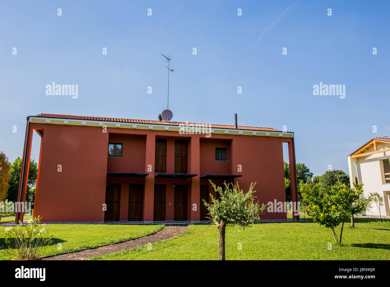 Ein schönes neu gebautes Haus mit grünen, großen Garten an einem sonnigen Tag Stockfoto