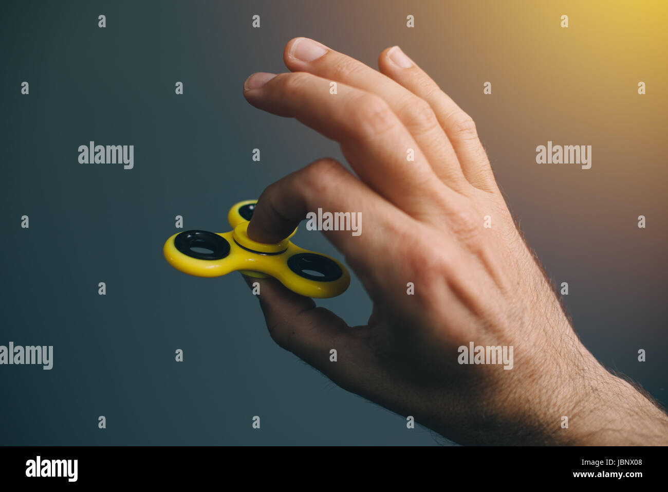 Gelbe Fidget Spinner in männlicher Hand, selektiven Fokus Stockfoto