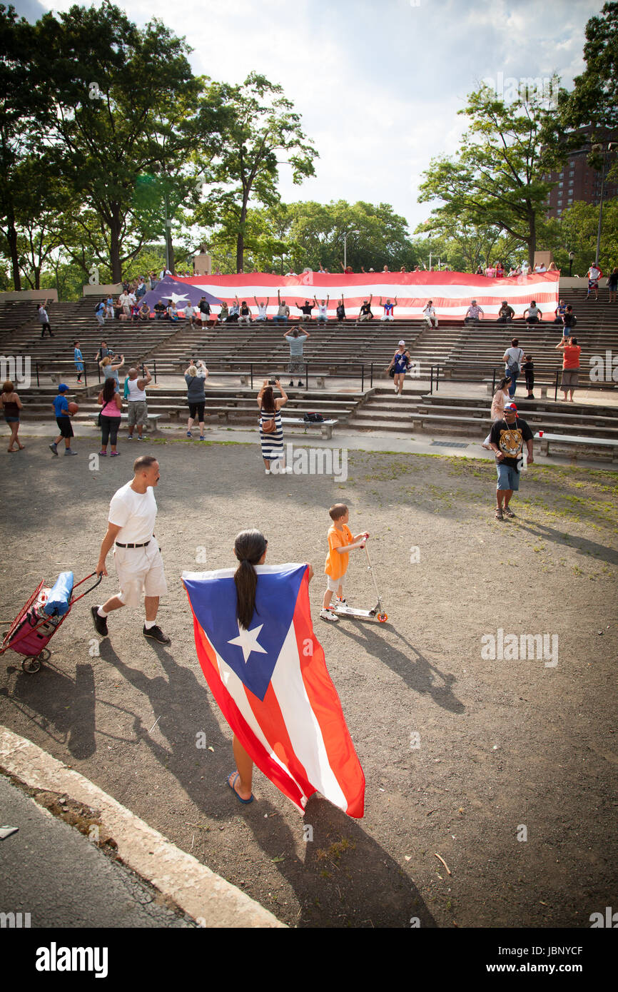 Eine riesige Puerto-ricanische Flagge wird während einer öffentlichen Demonstration von einer Menge hochgehalten, die Solidarität, Patriotismus und kulturelle Identität zeigt. Stockfoto