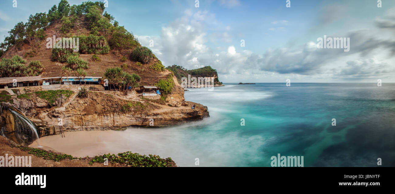 Einzigartige Seenlandschaft Bild des Pantai Banyu Tibu Strand in Ost-Java, Indonesien wo frisches Quellwasser auf eine kleine Bucht an einem weißen Sandstrand fällt Stockfoto