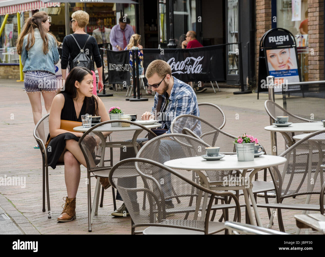 Ein paar Mischlinge sitzen an einem Tisch vor einem Café in Peascod Street in Windsor, UK. Stockfoto