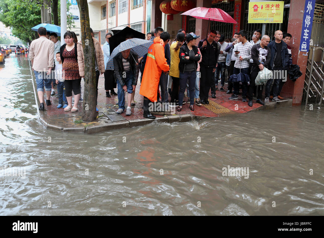 Guiyang, China Provinz Guizhou. 11. Juni 2017. Menschen stehen einer überfluteten Straße in Weining County, Südwesten Chinas Provinz Guizhou, 11. Juni 2017. Starker Regen getroffen Guizhou seit Sonntag. Bildnachweis: He Huan/Xinhua/Alamy Live-Nachrichten Stockfoto