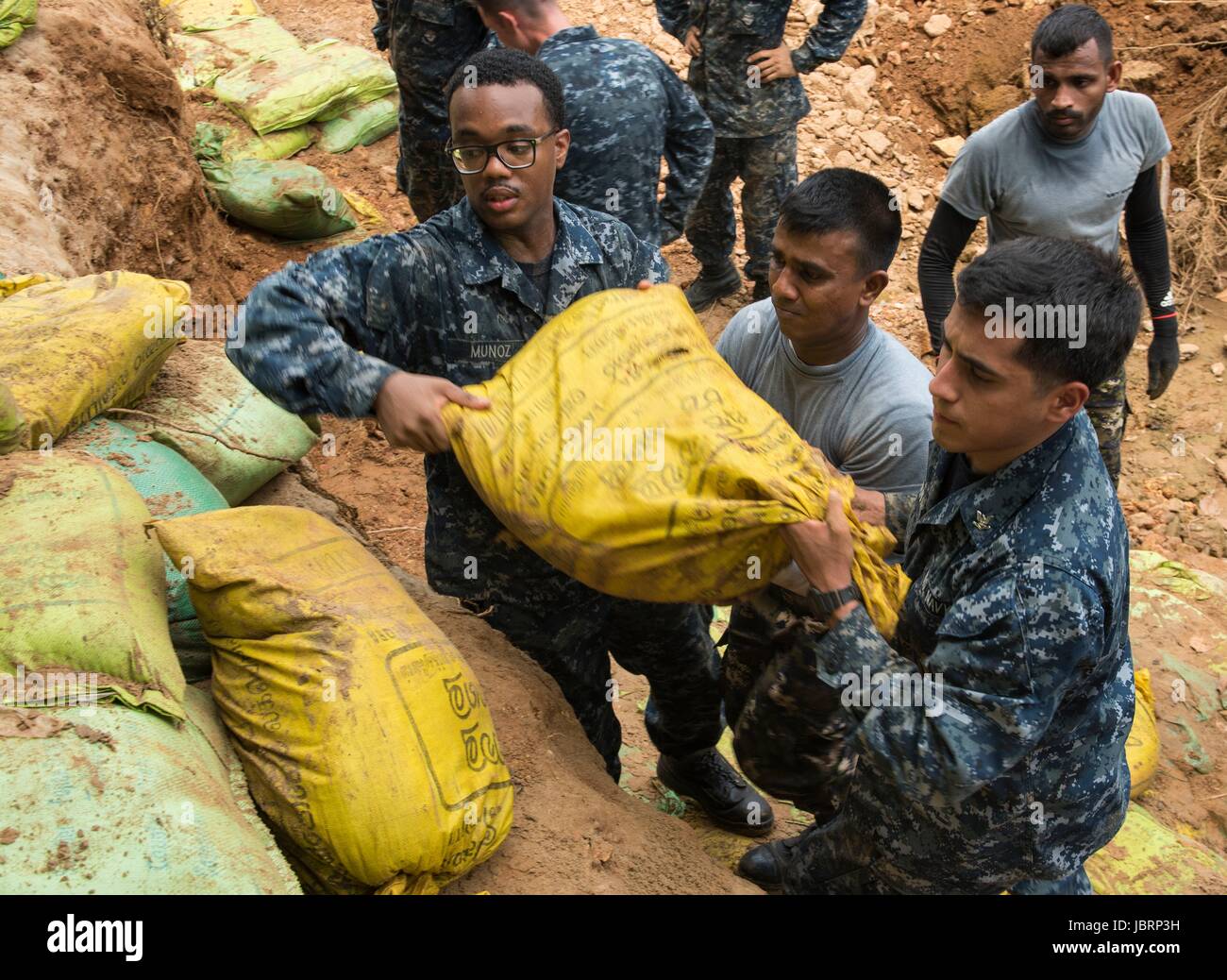 US Navy Matrosen aus der Ticonderoga-Klasse geführt-Raketenkreuzer arbeiten USS Lake Erie neben Sri Lanka Marines, Dämme beschädigt in schwere Überschwemmungen und Erdrutsche 12. Juni 2017 in Matara, Sri Lanka zu reparieren. Mehr als 600.000 mussten aus ihren Häusern durch Monsunregen töten mehr als 200 und Tausende gestrandet. Stockfoto