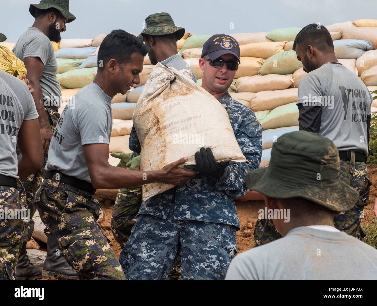 US Navy Matrosen aus der Ticonderoga-Klasse geführt-Raketenkreuzer arbeiten USS Lake Erie neben Sri Lanka Marines, Dämme beschädigt in schwere Überschwemmungen und Erdrutsche 12. Juni 2017 in Matara, Sri Lanka zu reparieren. Mehr als 600.000 mussten aus ihren Häusern durch Monsunregen töten mehr als 200 und Tausende gestrandet. Stockfoto