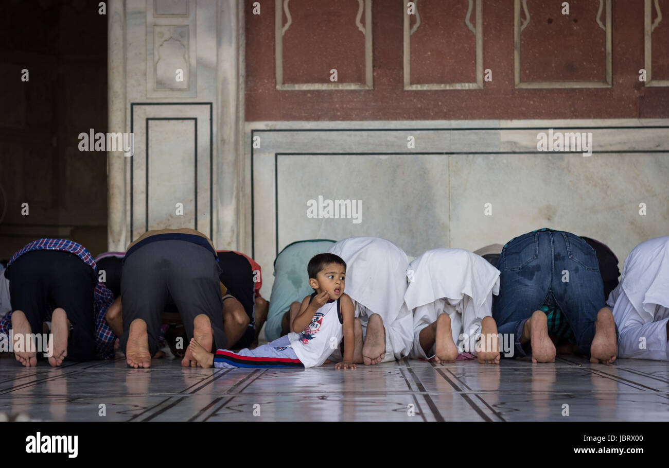 NEU-DELHI, INDIEN. Juni 7,2017: ein Junge schaut zu, wie Menschen Namaz während des Heiligen Monats Ramadan in der Galerie der Jama Masjid, Delhi, Indien lesen. Stockfoto