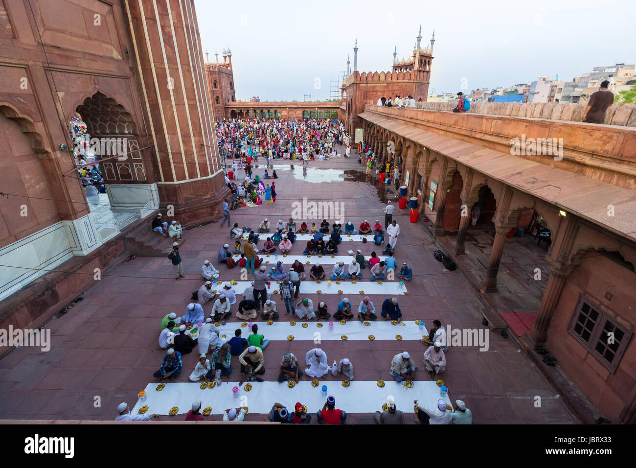 NEU-DELHI, INDIEN. Juni 8,2017: vom Balkon des berühmten Jama Masjid-Moschee von Delhi gesehen, Menschen sitzen in Zahlen, ihr Fasten zu brechen. Stockfoto