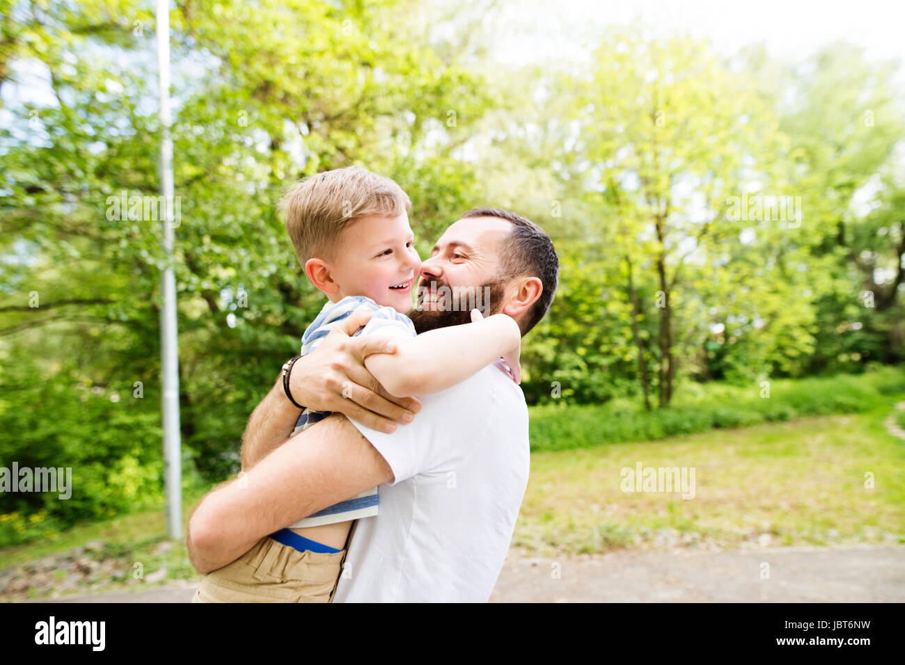 Junger Vater mit kleinen Sohn im grünen sonniges Gemüt. Stockfoto