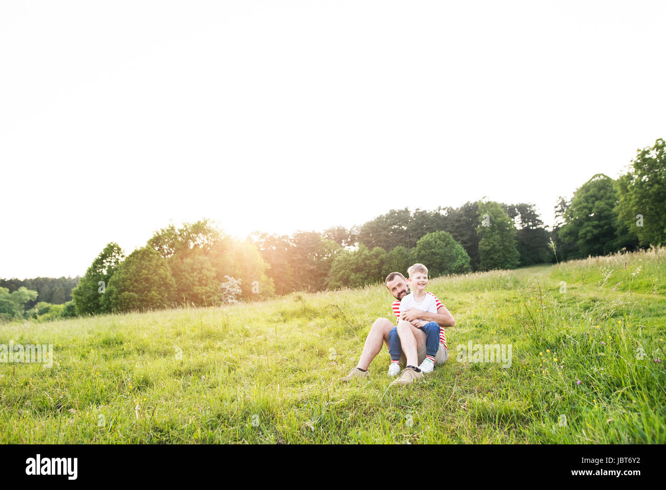 Hipster Vater und kleinen Sohn auf der grünen Wiese. Sonnigen Sommertag. Stockfoto